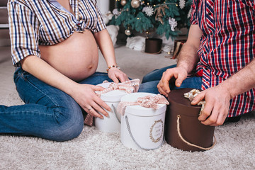 pregnancy, winter holidays and people concept - close up of husband giving christmas present to his pregnant wife at home