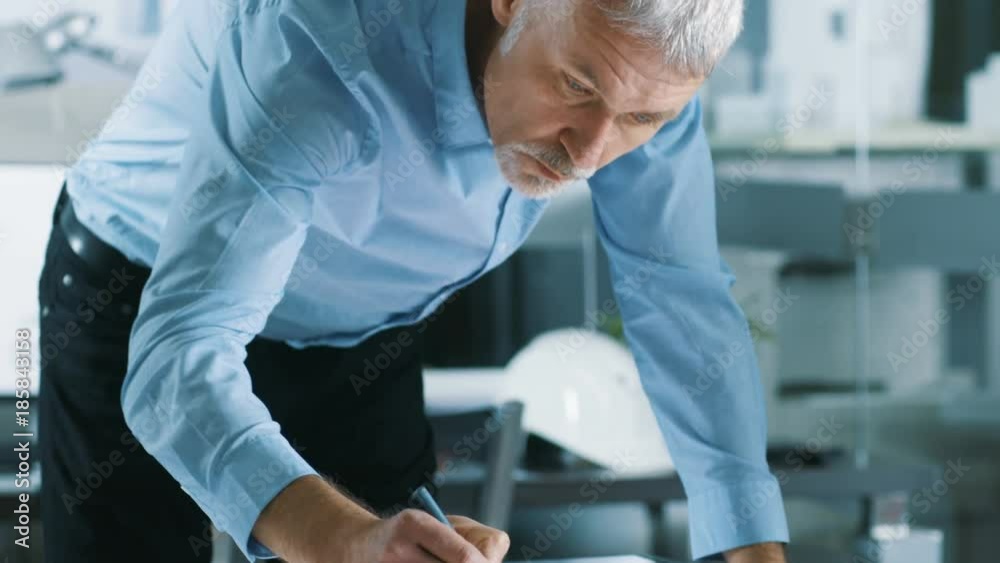 Poster senior architectural engineer draws building concept on a graphics tablet display vertical touchscre