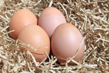 Brown eggs in box or crates and some straw made of paper. shallow depth of field.