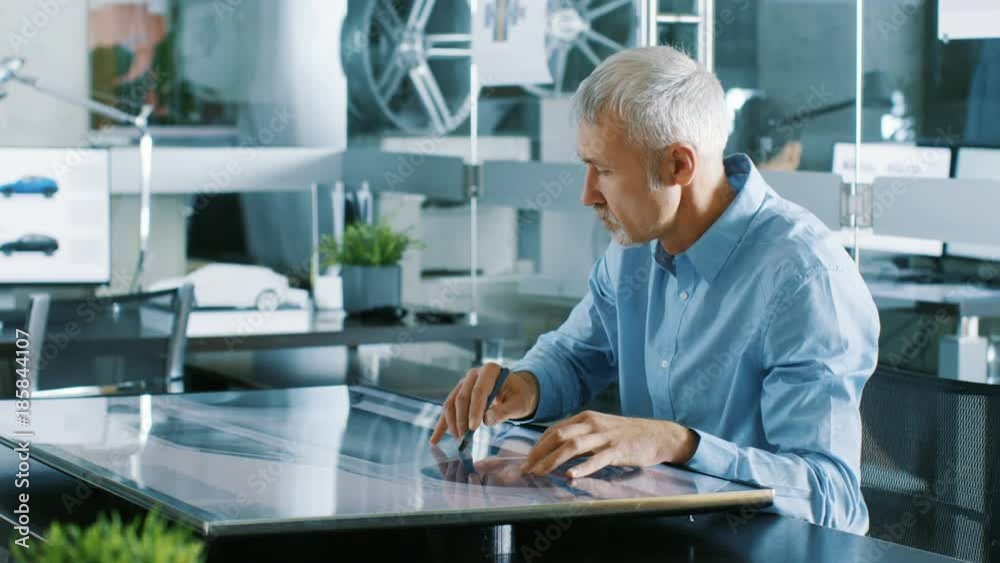 Poster experienced automotive designer works with digital display graphics tablet touschreen table, drawing