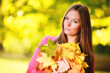 Naklejka premium Fall season. Portrait girl woman with bunch of autumnal leaves