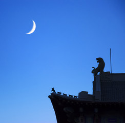White moon in the blue sky, rooftop of pavilion styles building.