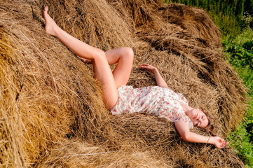 Young attractive woman relaxes on hay
