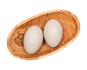 Unwashed fresh organic gmo and soy free pasture raised chicken eggs in wooden bowl isolated on white background