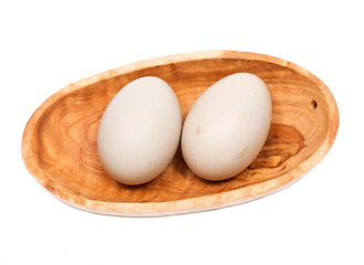 Unwashed fresh organic gmo and soy free pasture raised chicken eggs in wooden bowl isolated on white background