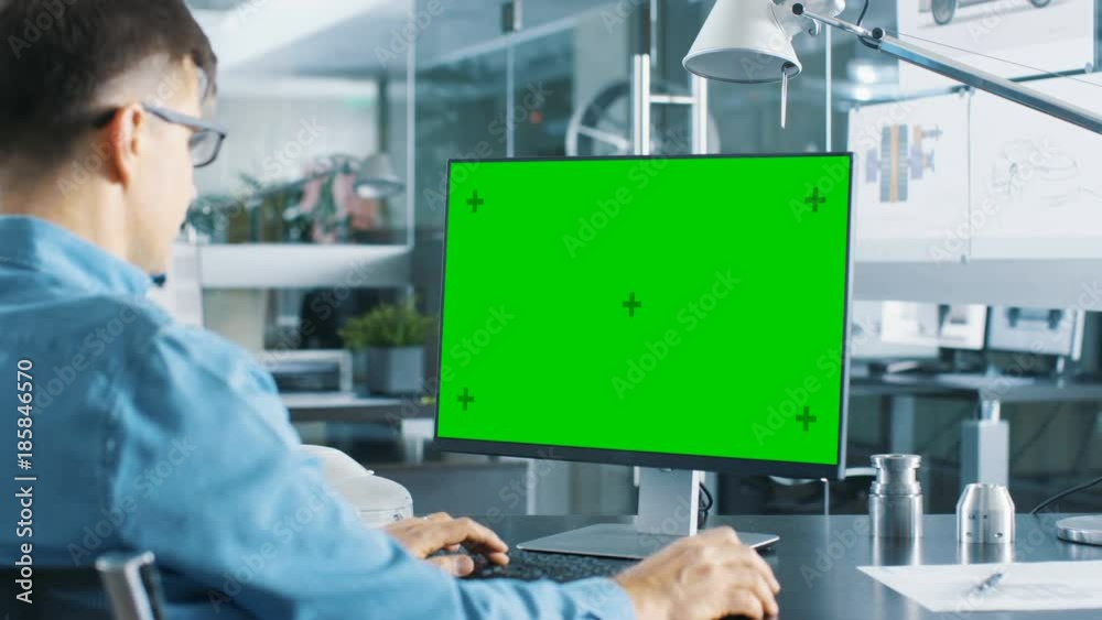 Poster Automotive Engineer Working on a Personal Computer With Isolated Mock-up Green Screen on it. Shot on RED EPIC-W 8K Helium Cinema Camera.