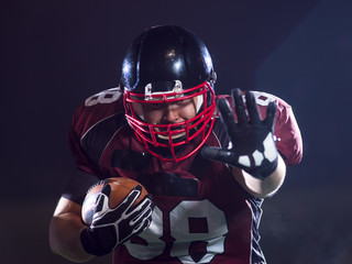 American football player holding ball while running on field