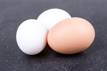 Farm fresh and commercial eggs on a black background