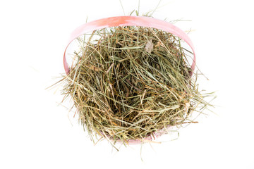 Pink easter basket filled with hay on a white background