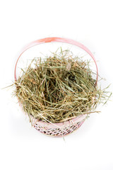 Obraz premium Pink easter basket filled with hay on a white background