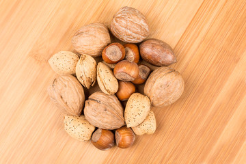 Mixed nuts in shell on a wood background