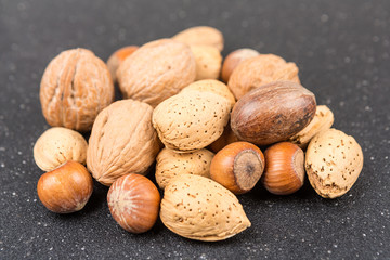 Mixed nuts in shell on a black background
