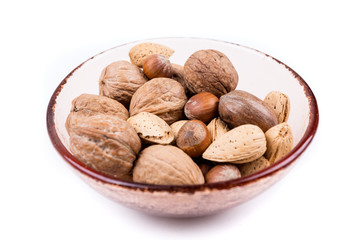 Mixed nuts in shell  in a bowl on a white background