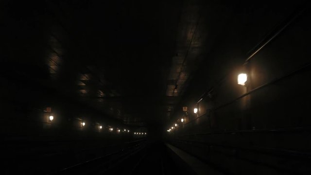 Driverless metro ride trough the tunnels arriving at station
