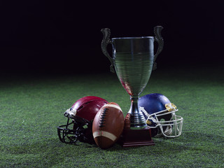 closeup of american football,helmets and trophy