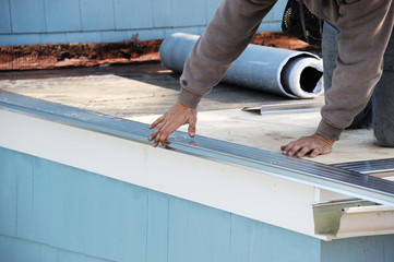 Handy man working on repairing the roof of the house