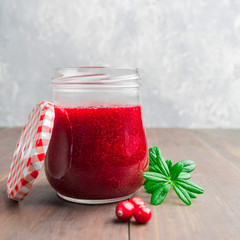 Closeup view of cranberry jam in glass jar with cover
