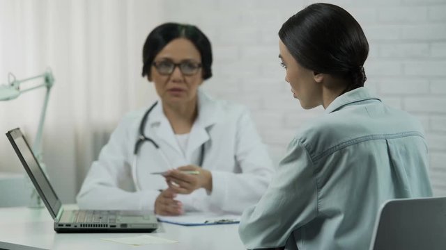 Female doctor informs about bad diagnosis, patient upset, incurable disease