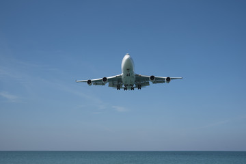 Fototapeta na wymiar An airplane landing over the sea