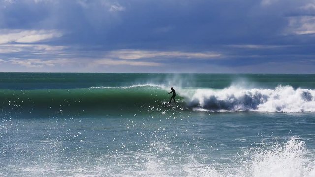 a surfer performs a re-entry on a wave at a point break near kaikoura in new zealand- recorded at 1080p 60fps