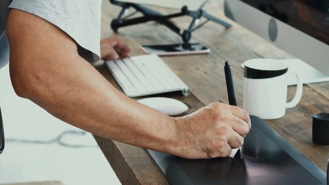 close up at male hand writing with electronics pen tablet