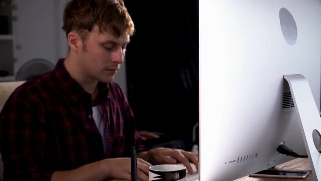 Young Caucasian freelancer male Working on a Computer at His Home Office