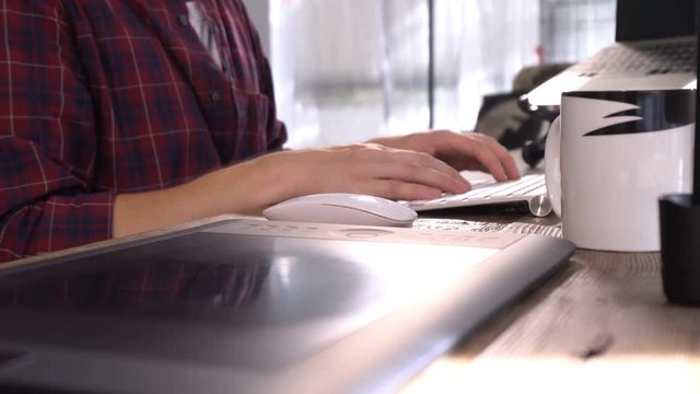 Zoom in the hands typing on white keyboard