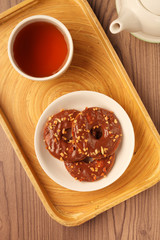 Chocolate ring cookies on a plate on wooden background