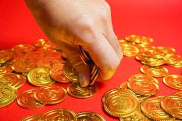 金貨を手につかむ　成功をつかむ、大金を手に入れるなどのイメージ
