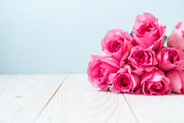 pink rose in vase on wood background
