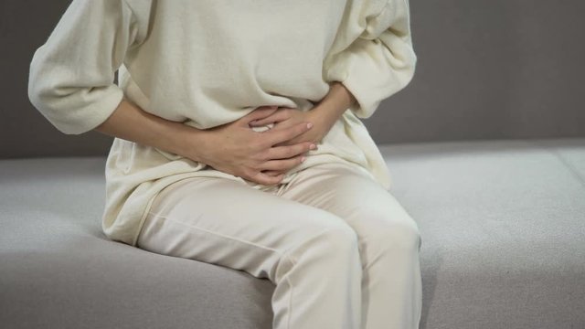 Young woman suffering from strong menstrual or stomach ache, gynecology problems
