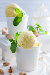 Homemade pistachio ice cream in white cups, selective focus