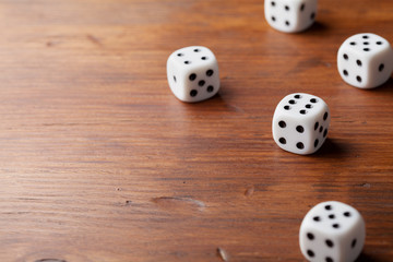 Game of chance concept. White dice on rustic wooden board.
