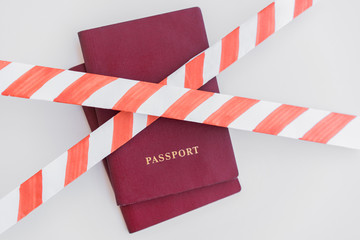 Fototapeta premium Two Red Passports behind the red-white prohibiting tape