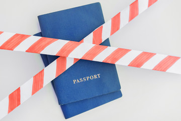 Fototapeta na wymiar Two blue Passports behind the red-white prohibiting tape