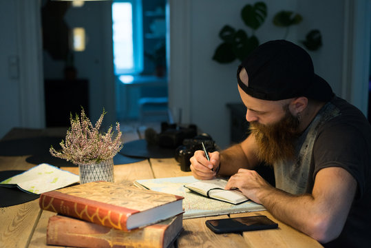 Man writing in diary while sitting at home