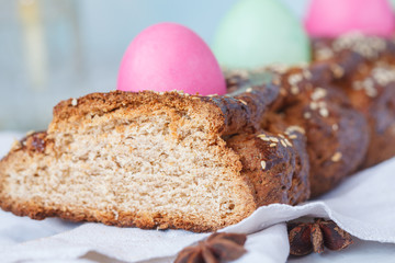 Traditional Greek Easter bread - tsoureki, sliced in Easter decoration with painted eggs and flowers.