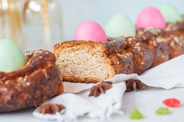 Traditional Greek Easter bread - tsoureki, sliced in Easter decoration with painted eggs and flowers.