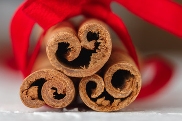 Festive wrapped cinnamon sticks with red ribbon