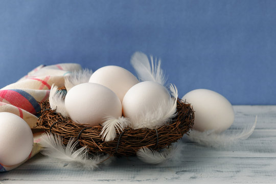 White chicken eggs in the nest with feathers
