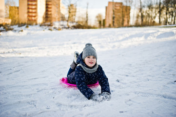 Fototapeta na wymiar Cute little girl with saucer sleds outdoors on winter day.