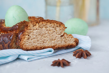 Traditional Greek Easter bread - tsoureki, sliced in Easter decoration with painted eggs and flowers.