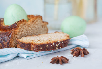 Traditional Greek Easter bread - tsoureki, sliced in Easter decoration with painted eggs and flowers.