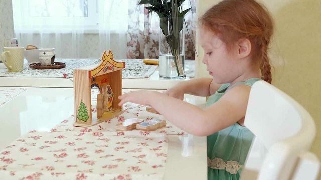 Beautiful girl at the table playing in a puppet theater with toys