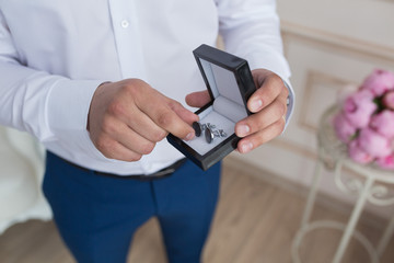 Groom buttons on a white shirt cufflinks at wedding morning