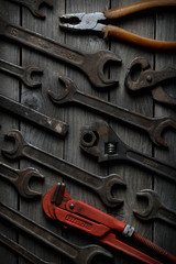 Dirty set of hand tools on a wooden background. Old rusty tools Sales tools for assembly workers. Old shop Old working. Vintage working tools (drill, saw, ruler and others) on wooden background