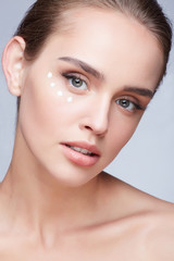 Obraz premium Young beautiful woman with cream under eyes