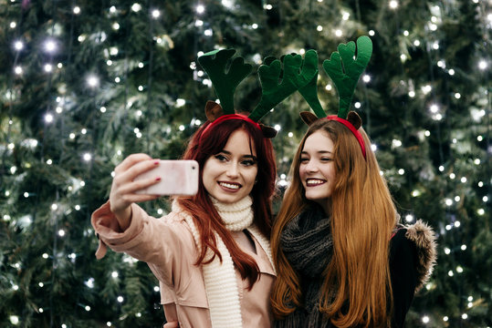 Smiling women taking selfie at illumination