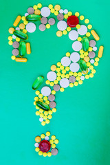 Pills and capsules forming a question mark