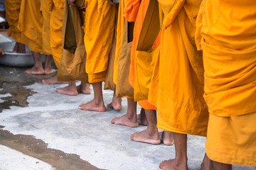 Queue of barefoot monks with foot wash ceremonial in south of Vietnam